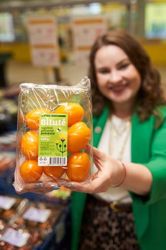 Moteris „Iki“ parduotuvėje laiko naujo prekės ženklo „Bitutė“ mandarinus
